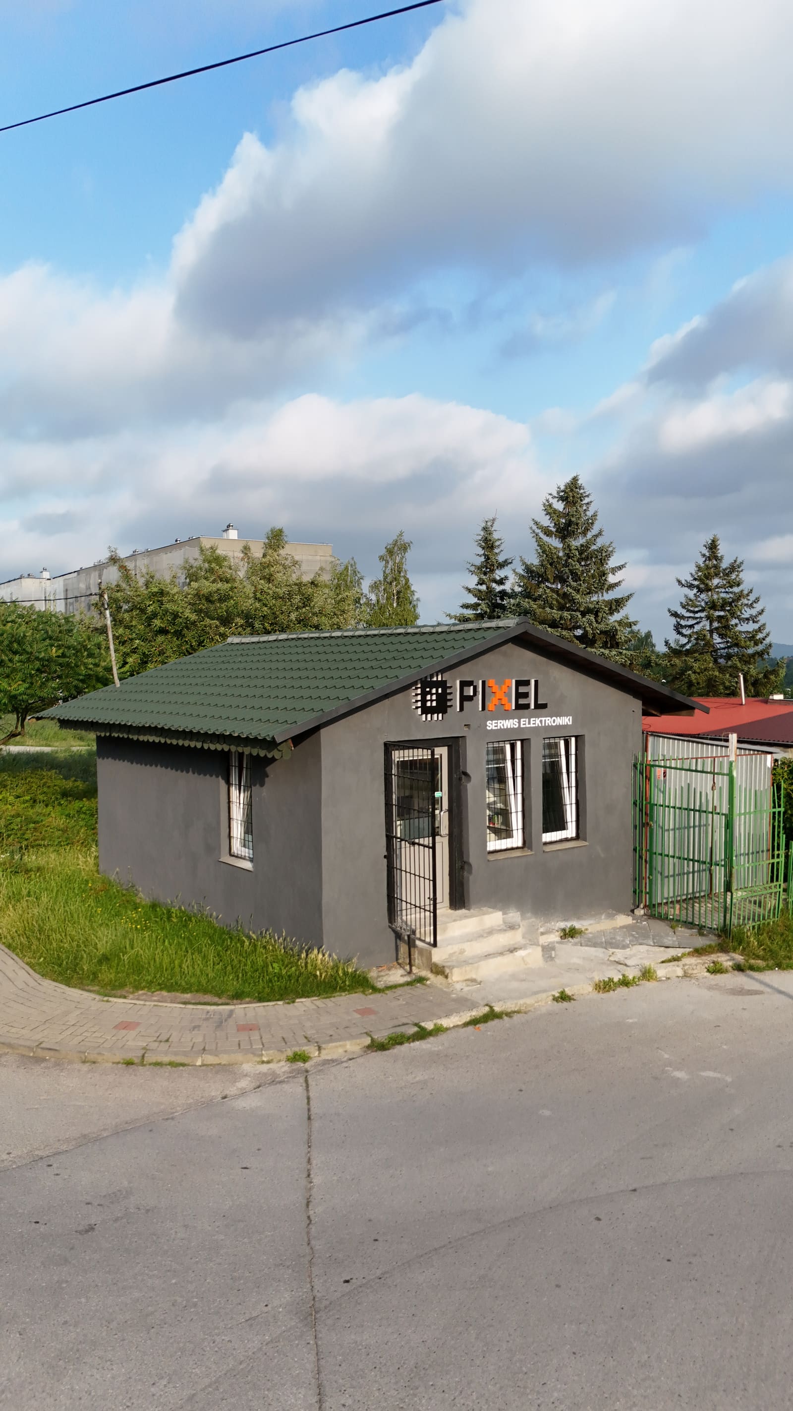 Budynek serwisu Pixel widziany z góry — zielony dach i szyld od strony ulicy