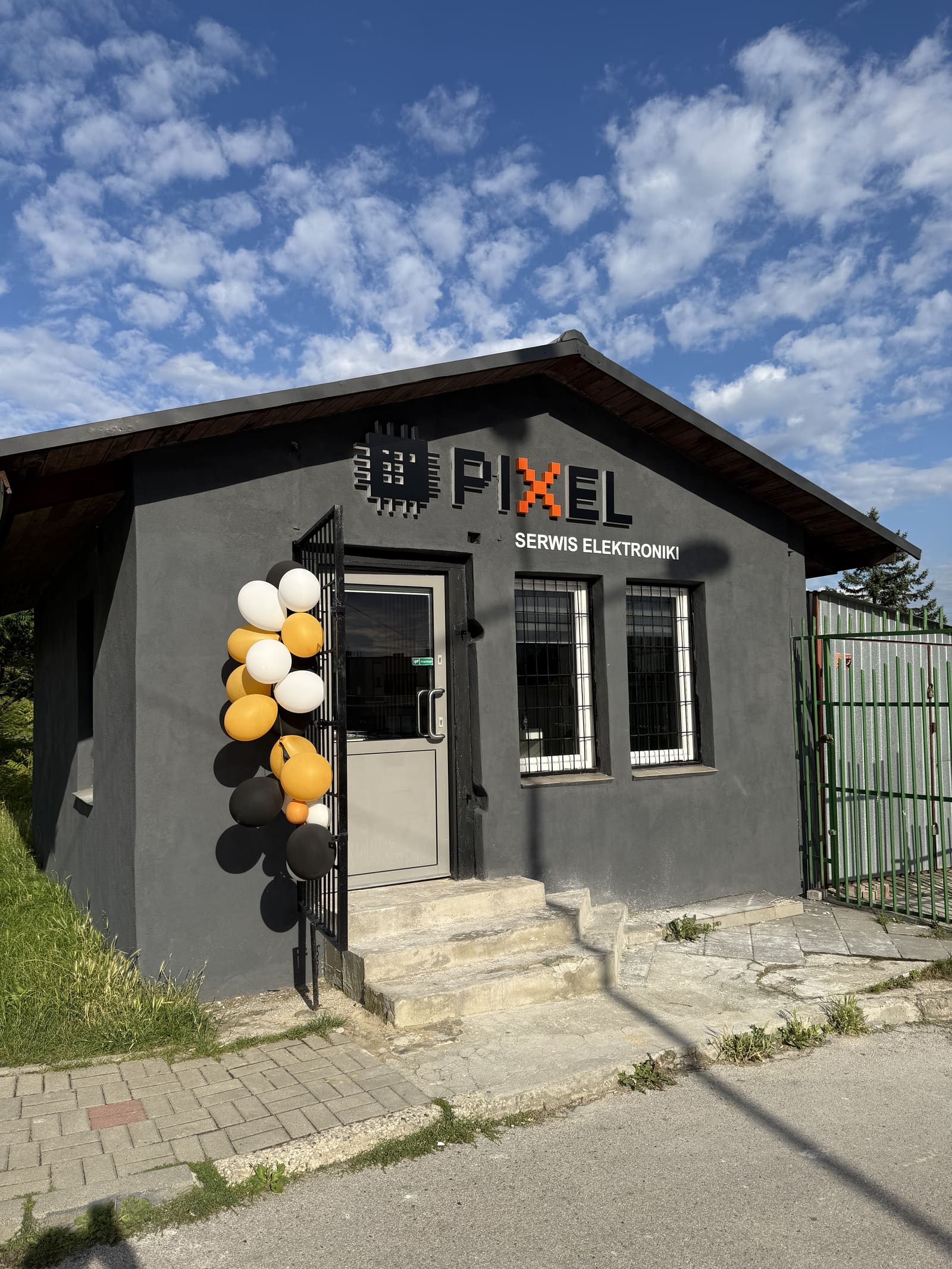Budynek serwisu Pixel od frontu — szyld „Pixel Serwis Elektroniki" nad wejściem
